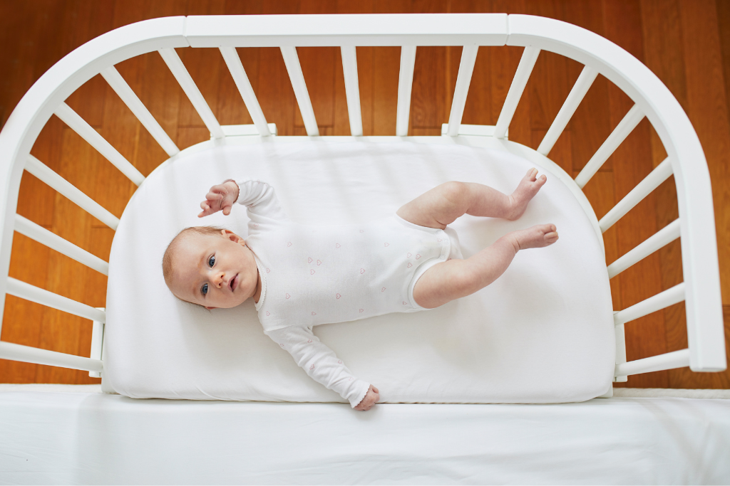 A cute, adorable baby in his crib mattress
